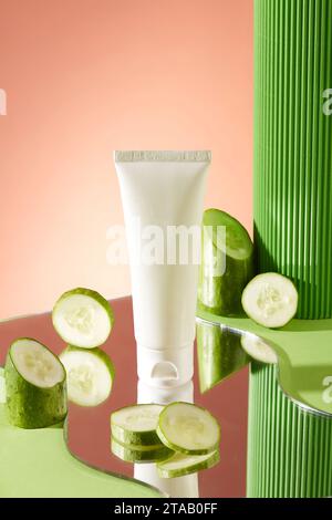 Geometric shaped mirror with some round slices of cucumber and unlabeled tube placed on. Natural cosmetic concept. Empty label for branding mockup Stock Photo