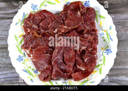 Thin slices of beef pastrami, made from beef brisket, raw meat is brined, partially dried, seasoned with herbs and spices, then smoked and steamed, li Stock Photo