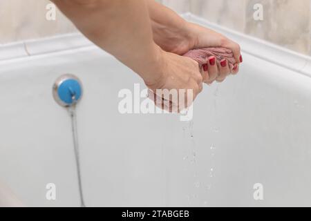 female hands wringing out a wet rag Stock Photo