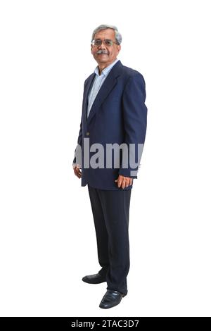 A full length shot of a smiling senior Indian businessman or executive with grey hair in a light blue shirt and suit jacket isolated on white Stock Photo