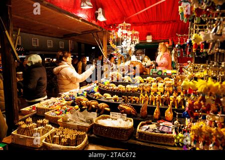 One of the German Stalls on New Street during Birmingham Frankfurt Christmas Market. The largest authentic German Christmas market outside of Germany or Austria. This year saw the iconic City Centre fountain 'Floozie in the Jacuzzi' bathed in red and green light joining other attractions welcoming the thousands of visitors from all over the world. Over 100 stalls lined the main streets in the City Centre and the market will be open until Christmas Eve.  Birmingham's Frankfurt Christmas Market offers a large range of traditional goods and gifts and a selection of tempting food and drink. Stock Photo