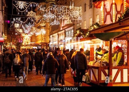 The view along New Street during Birmingham Frankfurt Christmas Market. The largest authentic German Christmas market outside of Germany or Austria. This year saw the iconic City Centre fountain 'Floozie in the Jacuzzi' bathed in red and green light joining other attractions welcoming the thousands of visitors from all over the world. Over 100 stalls lined the main streets in the City Centre and the market will be open until Christmas Eve.  Birmingham's Frankfurt Christmas Market offers a large range of traditional goods and gifts and a selection of tempting food and drink. Stock Photo