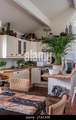 West African Kuba cloth on kitchen table with African carvings in colonial style single-storey home. Truro, Cornwall, UK. Stock Photo