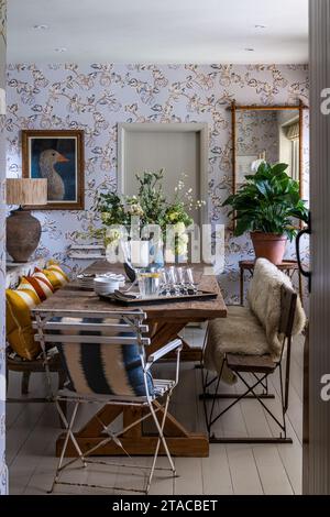 Locally sourced furniture with Pumpkin wallpaper by Eloise Home in 1930s Arts and Crafts style home. Hove, East Sussex, UK. Stock Photo