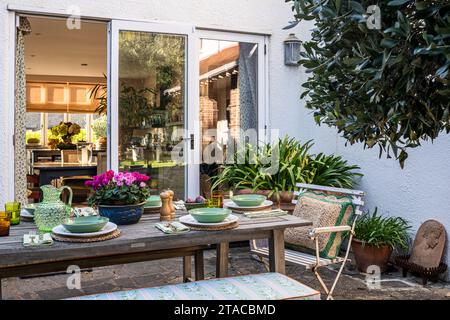 Set table on terraced exterior of 1930s Arts and Crafts style home. Hove, East Sussex, UK Stock Photo
