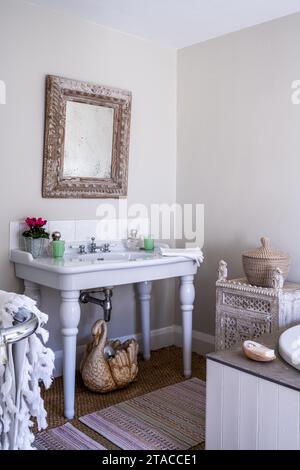 Carved mirror and cabinet with swan ornament in 1930s Arts and Crafts style home. Hove, East Sussex, UK. Stock Photo