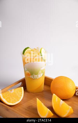 Take away glass of fresh orange juice in plastic cup Stock Photo