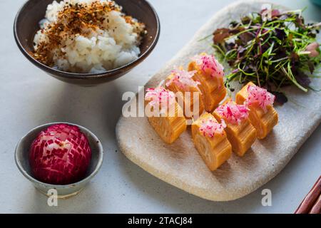 Japanese breakfast: egg roll tamagoyaki, herb salad and rice Stock Photo
