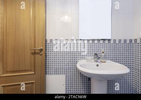 Small bathroom with white porcelain sink with matching pedestal Stock Photo