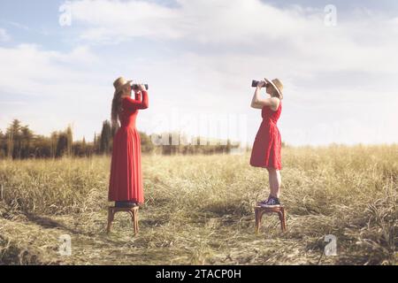 surreal images of two women with telescope facing each other, abstract concept Stock Photo