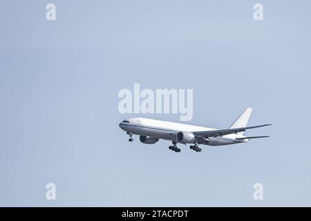 An airplane cargo jet descending altitude to land at an airport Stock Photo