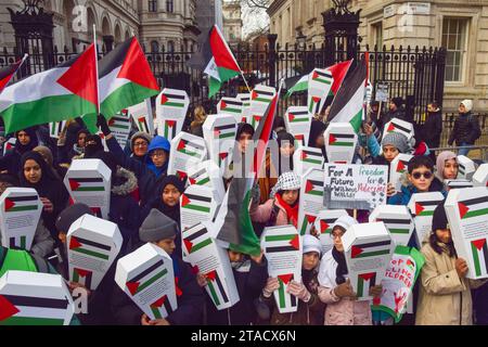London, UK. 30th November 2023. Pro-Palestine children and parents hold cardboard “child coffins” outside Downing Street representing over 6000 Palestinian children reportedly killed by Israeli forces or missing in Gaza, calling for a permanent ceasefire as Israel pause their fighting with Hamas. Credit: Vuk Valcic/Alamy Live News Stock Photo