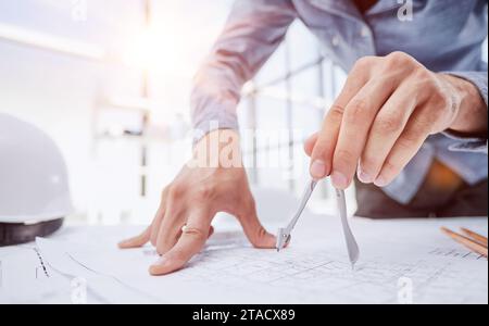Architect working on drawing table in office Stock Photo