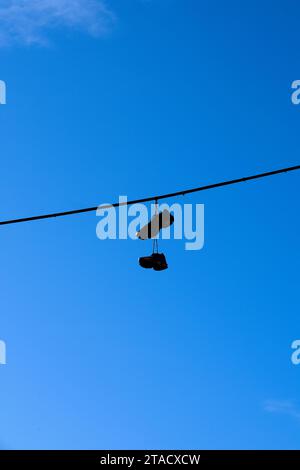 Shoes hanging from wire Stock Photo