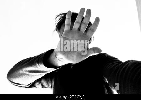 Man showing his hand, hiding his face. Stock Photo
