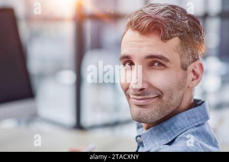 happy freelancer looking at camera during making project for remote job making notes. Stock Photo