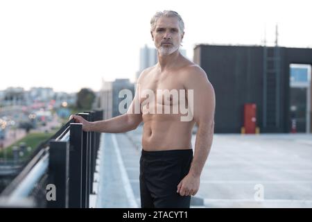 Tired Exhausted Middle-aged Man Resting After Running Outdoors. Handsome Runner Taking Break After Fitness Workout Stock Photo