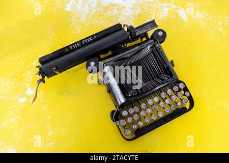 The Fox vintage typewriter on yellow background Stock Photo
