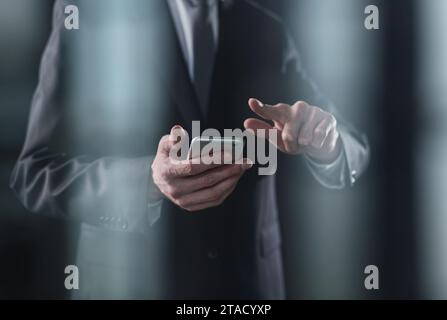 closeup of a businessman presses a finger on the smartphone screen. Stock Photo