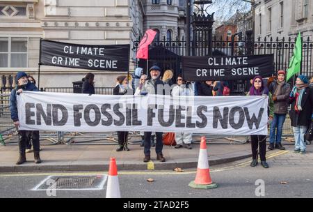 London, UK. 30th November 2023. Extinction Rebellion activists brand Downing Street a “climate crime scene” as COP28 begins. The activists are calling out the government for rolling back on climate pledges and for issuing 100 new fossil fuel licences. Credit: Vuk Valcic/Alamy Live News Stock Photo