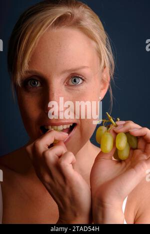 Junge Frau isst Trauben, Deutschland, BLF *** Young woman eating grapes, Germany, BLF 07000982 xH Credit: Imago/Alamy Live News Stock Photo