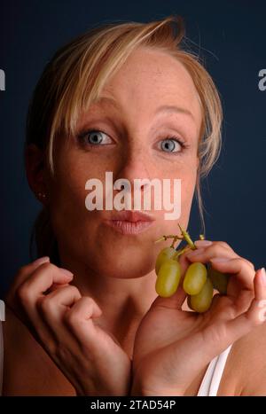 Junge Frau isst Trauben, Deutschland, BLF *** Young woman eating grapes, Germany, BLF 07000983 xH Credit: Imago/Alamy Live News Stock Photo