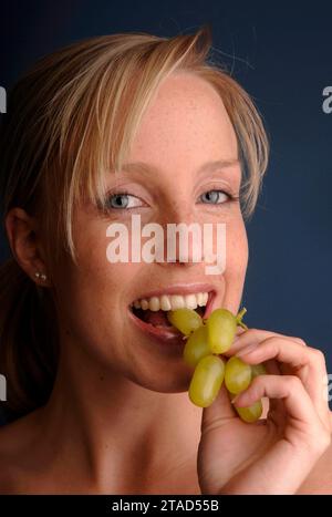 Junge Frau isst Trauben, Deutschland, BLF *** Young woman eating grapes, Germany, BLF 07000973 xH Credit: Imago/Alamy Live News Stock Photo