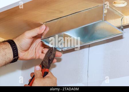 Placement of for kitchen hood by worker during installation in kitchen cabinet Stock Photo