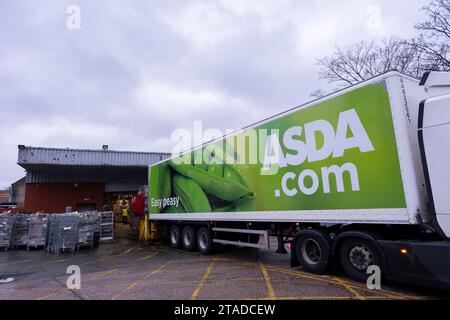 Asda delivery logistics lorry unloading groceries at their supermarket in Kings Heath on 27th November 2023 in Birmingham, United Kingdom. Asda Stores Ltd. is a British supermarket retailer, headquartered in West Yorkshire. The company was founded in 1949 and was listed on the London Stock Exchange until 1999 when it was acquired by the American retail giant Walmart for £6.7 billion. Stock Photo