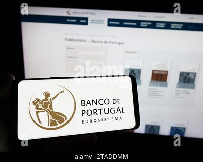 Person holding smartphone with logo of Portuguese central bank Banco de Portugal in front of website. Focus on phone display. Stock Photo