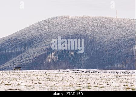 Lonely empty bench on the horizon in nature. Loneliness concept. Foothills of the Radhost mountain in Czech republic. Landscape covered by snow. Stock Photo
