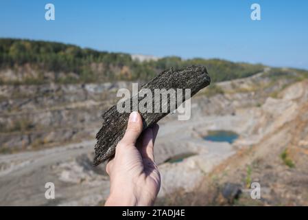 A scenic landscape showing a mining site with a prominent graphite deposit, heavy mineral production equipment, and natural rock formations in the sur Stock Photo