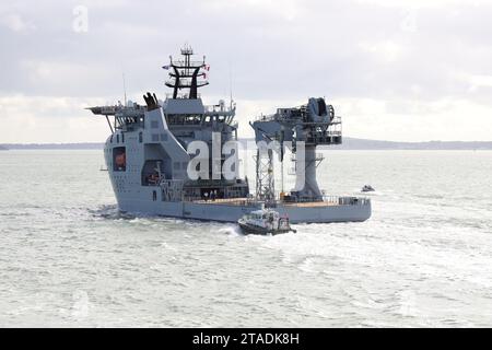 The Admiralty pilot’s launch stays close to the stern of the Royal Fleet Auxiliary’s latest ship RFA PROTEUS as the vessel heads into The Solent Stock Photo