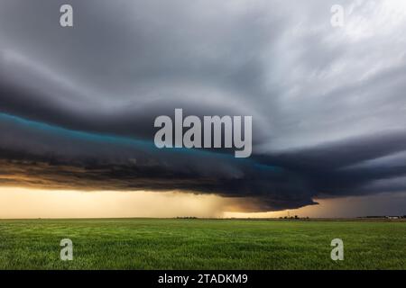 An ominous shelf cloud leads a severe thunderstorm across Kansas at sunset Stock Photo