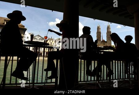 Zurich, Switzerland - June 03, 2017: People relax in cafe with wiev on the Great Minster church (Grossmunster) in Zurich, Switzerland. Stock Photo