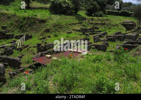 Green grass and red flowers in the Etruscan burial ground of Crocifisso del Tufo in Orvieto, Umbria, Italy. Stock Photo