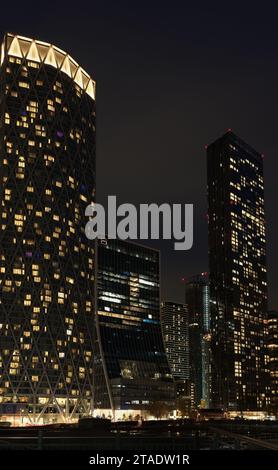 Newfoundland Quay and Landmark Pinnacle, skyscraper blocks of waterside apartments on either side of Société Génerale building, Canary Wharf, at night. Stock Photo