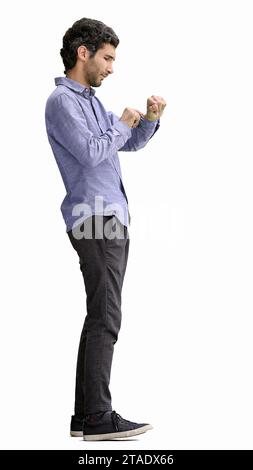 young man in full growth. isolated on white background looking at wristwatch Stock Photo
