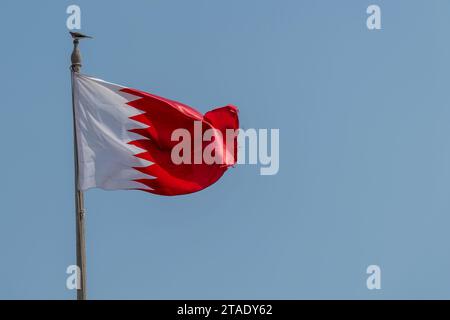 Doha, Qatar, October 31, 2023. Flag of Qatar, white and red on a blue sky background Stock Photo