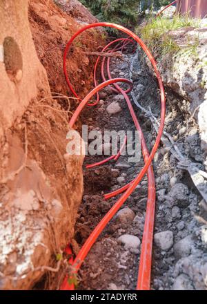 Orange industrial optic fibre cables installed in ground Stock Photo