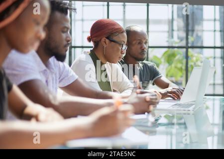 Employees working at computer together, discussing content. Stock Photo