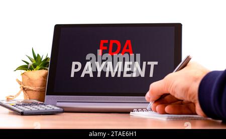FDA Food and Drug Administration payment symbol. Concept words FDA payment on beautiful black tablet. Beautiful white background. Calculator. Business Stock Photo
