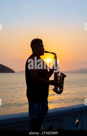 Santos, Brazil. November 12, 2023. Musician playing saxophone during sunset in Santos. Stock Photo