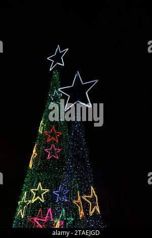 Image on black of two Christmas trees built with LED lights to decorate the city in healthy competition Stock Photo