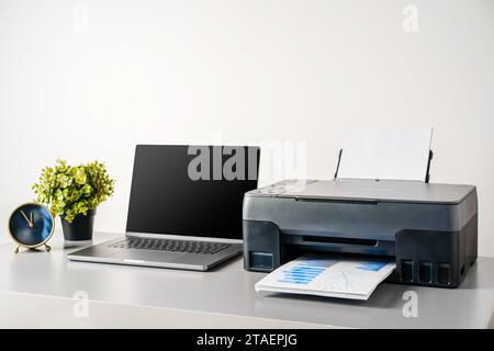 Printer and laptop on grey table in office Stock Photo