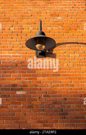 Vintage old street lantern with on a brick wall. Wall street light. Old style lantern, brick wall with shadow. Old grunge street. Grungy urban backgro Stock Photo