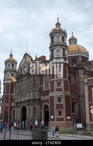 Mexico City, Federal District, Mexico. October 14, 2023: Visitors and pilgrims rest in front of the old Basilica of Our Lady of Guadalupe, a Roman Cat Stock Photo