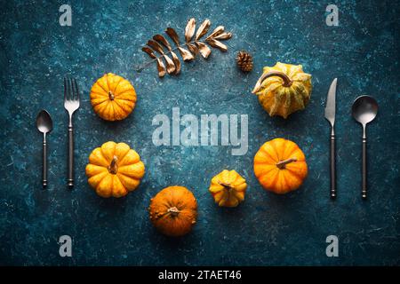 Autumn Pumpkin on blue vintage backdrop with kitchen utensils fork, knife, spoon and copy space for text,  Thanksgiving Background Stock Photo