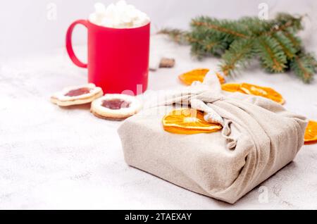 Eco-friendly and zero waste Xmas gift wrapping in traditional Japanese Furoshiki style in clothes with natural materials. Zero waste, environmental gi Stock Photo
