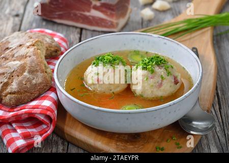 Delicious South Tyrolean bacon dumplings soup with hot beef broth and chives Stock Photo